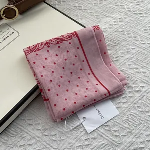 Detail of pink cotton-linen scarf featuring red dots and classic paisley border patterns