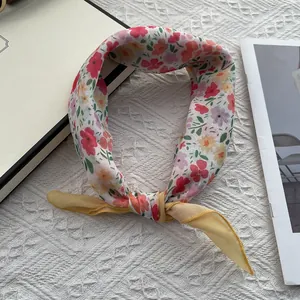 Detail of floral printed scarf with yellow trim on elegant white textured surface