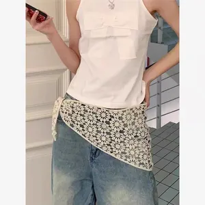 Close-up of white floral hollow lace belt paired with light blue denim wide-leg pants