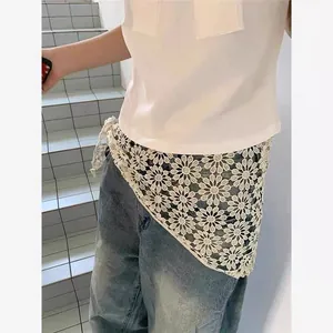 Detail of white cotton lace shawl with daisy crochet pattern on casual outfit