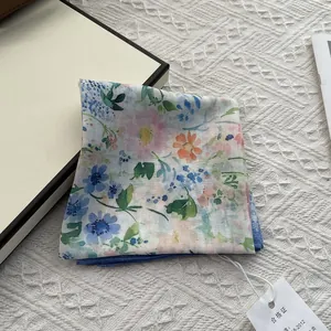 Close-up of floral cotton linen scarf with blue flower pattern and product tag