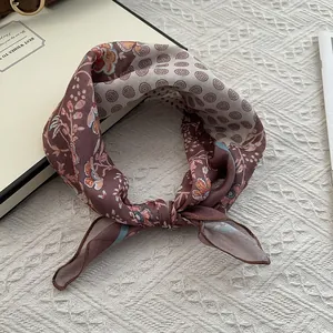 Détail macro du foulard en soie rétro à fleurs et pois sur une surface texturée