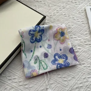 Detail of floral printed cotton linen square scarf with blue and yellow hand-painted patterns