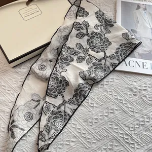 Floral triangular headscarf with black flower pattern on cream fabric for women
