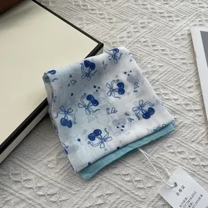 Detail of floral cotton scarf showing cherry patterns and delicate edge stitching