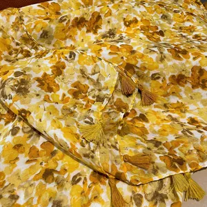 Detailed view of yellow floral cotton linen scarf with bright fringe tassels