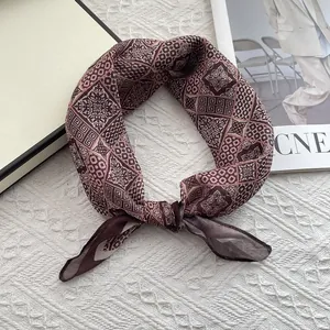 Detail of vintage geometric flower pattern on soft brown and pink cotton linen scarf