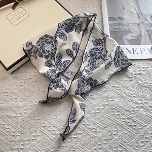 Macro detail of retro floral pattern on silk scarf with elegant navy blue flower print