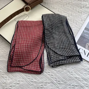 Close-up of red and blue checkered linen scarves with detailed stitched edges