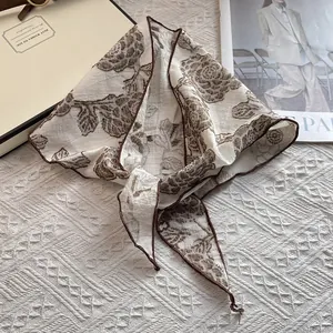 Detail of vintage floral triangular headscarf with brown rose print and stitched edges