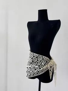 Detail of crochet daisy lace shawl with intricate hollow-out floral pattern and side ties