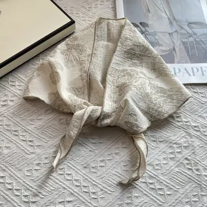 Detail shot of vintage floral pattern and crinkled texture on a beige cotton scarf
