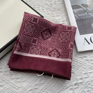 Detailed close-up of dark red vintage square scarf with white geometric patterns