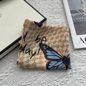 Elegant yellow checkerboard square scarf with blue butterfly print on knitting background