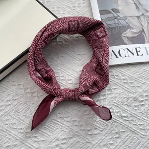 Macro view of burgundy silk scarf with vintage geometric patterns and silky texture