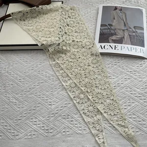 Close-up of floral lace texture on cream crochet daisy triangular shawl accessory