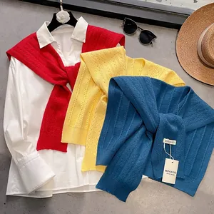 Women's hollow knit shawl wrap available in red, yellow, and blue over a white shirt