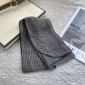 Detailed texture of navy blue plaid linen scarf on an elegant gift box setting
