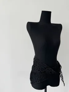Detailed view of the black lace floral crochet pattern on a cotton triangle shawl