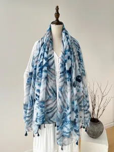 Detailed macro view of tie-dye scarf with fringe tassels and soft blue marble texture