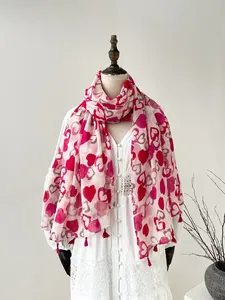 Detail view of heart-patterned cotton linen scarf with red tassels on lace dress
