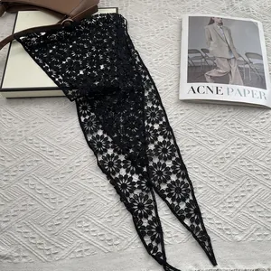 Detail of black crochet lace scarf with floral embroidery patterns on fashion magazine