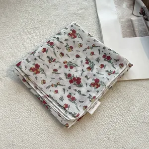 Dettaglio della sciarpa in cotone e lino a fiori con cuciture rifinite e trama del tessuto