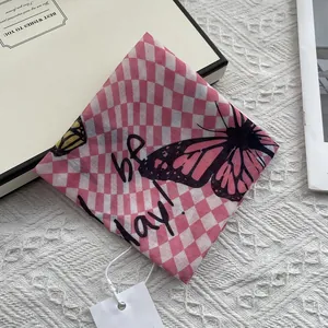 Detail of pink and white checkered silk scarf with butterfly print and hand-drawn letters