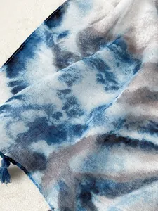 Detail of abstract blue ink wash linen scarf with fine texture and decorative tassels
