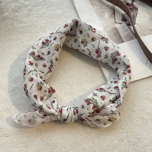 Piccolo foulard in cotone e lino a fiori legato a fiocco su una rivista d'epoca