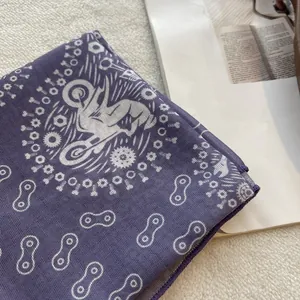 Detail of purple cotton scarf with white motorcycle print and fine overlock stitching