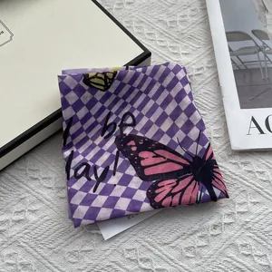 Detail of checkered silk scarf with pink butterfly pattern on elegant lace background