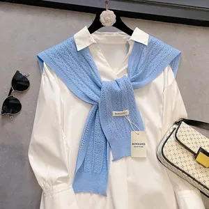Detail of light blue hollow-out knitted shawl with handmade brand label and tag
