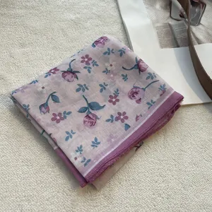 Detailed close-up of a floral cotton linen scarf with purple rose pattern and stitched edges