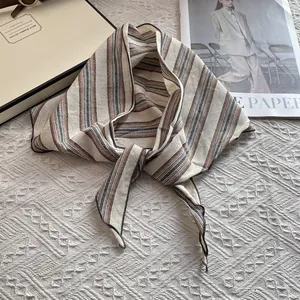 Detalle de un pañuelo de algodón y lino a rayas sobre un fondo blanco con textura