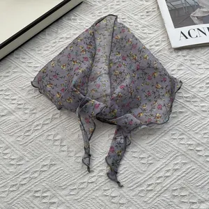 Vue détaillée du foulard triangle en mousseline à fleurs violettes avec couture fine