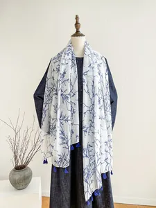 Detail of blue branch pattern scarf with stylish tassels on white fabric