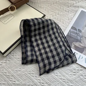 Detail of pure linen black and white checkered scarf with elegant blue stitched edges