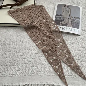 Close-up of brown floral crochet lace shawl showing delicate daisy patterns and texture