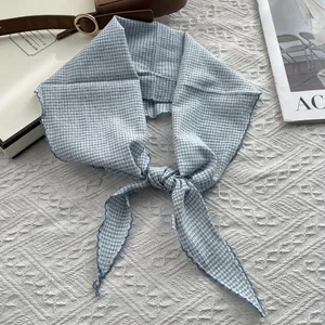 Detail shot of light blue checkered cotton scarf with fine stitching and knotted design