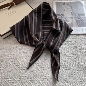 Vista de cerca de pañuelo de seda con rayas marrón y gris con elegante detalle de nudo