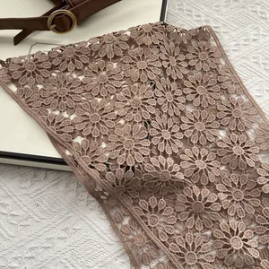 Detail of coffee brown daisy lace fabric with intricate hollowed-out crochet embroidery
