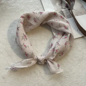 Dettaglio del foulard quadrato in cotone e lino con delicati motivi floreali viola