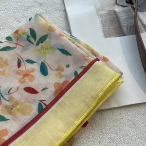 Detailed close-up of floral cotton scarf with intricate hem stitching and soft texture