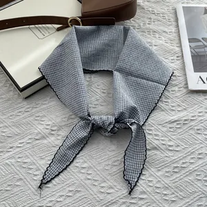 Detail of grey checkered cotton scarf featuring delicate black wavy stitched lace edges