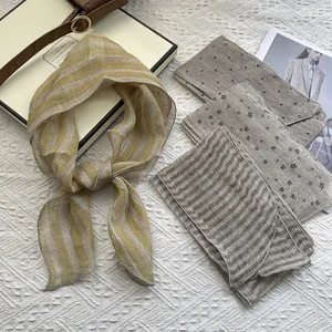 Detail of pure linen plaid scarf showing breathable texture and fine edge stitching