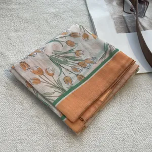 Detailed view of lightweight floral scarf with orange tulips on a soft white background