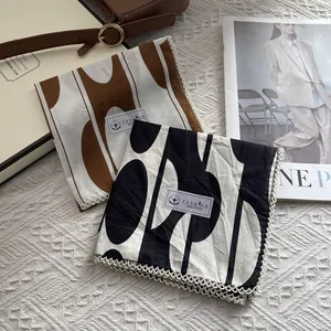 Vue à plat de foulards en coton imprimé géométrique avec bordure en dentelle rétro
