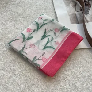 Detail of floral cotton square scarf with pink tulip print on a soft textured background