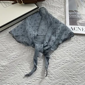 Detailed view of grey-blue floral cotton scarf with black patterns and overlocked edges